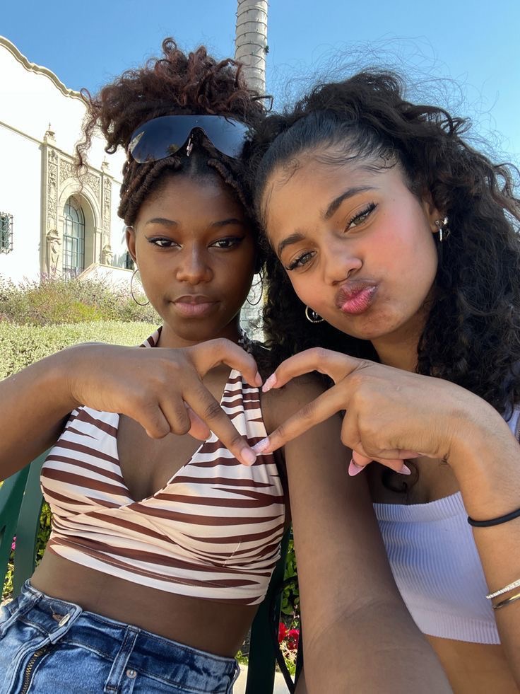 Two women making a heart together with their hands